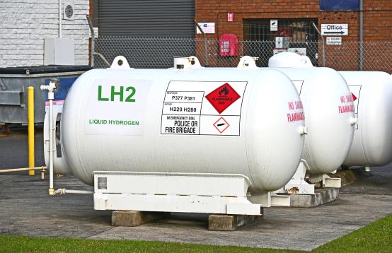 Three LH2 large gas cylinders in front of a factory.