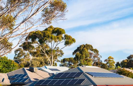 Image in outback Australia on a sunny day, blue sky with some clouds and a roof with solar panels on it.