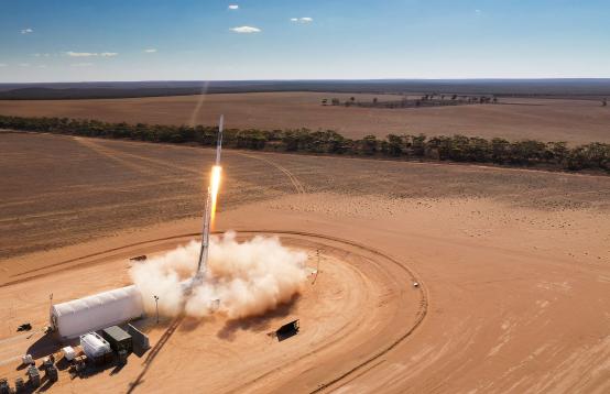 Image of a rocket blasting off in the Australian outback.