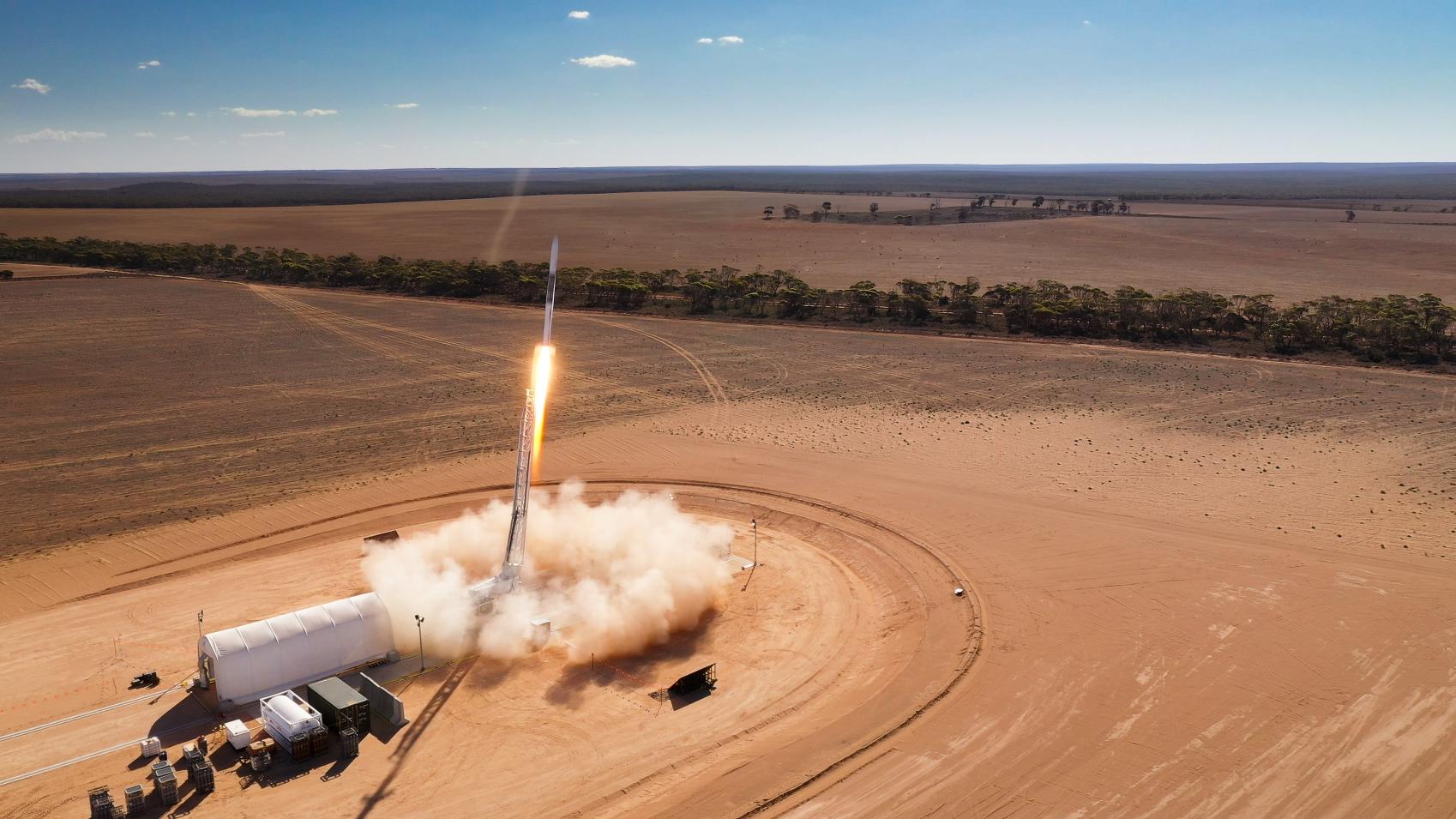 Image of a rocket blasting off in the Australian outback.