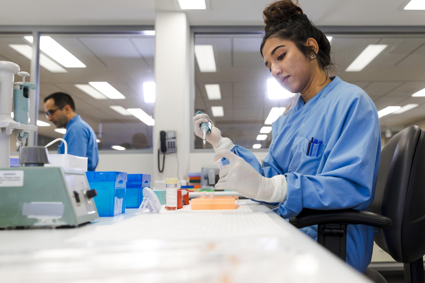 Image of a lady in a blue coat working in a lab