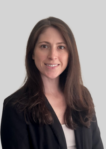 Aislinn Treloar - woman with long dark hair, wearing a white top and a black blazer smiling.